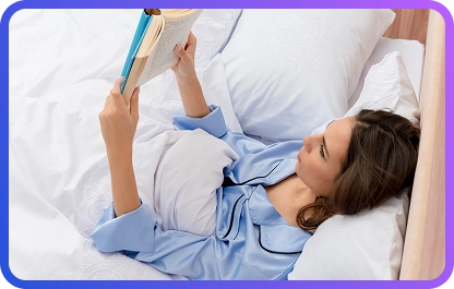 Een vrouw in een blauwe nachtjapon leest een boek, liggend in bed en zich ontspannend voor het slapengaan in een comfortabele thuis slaapkamer.